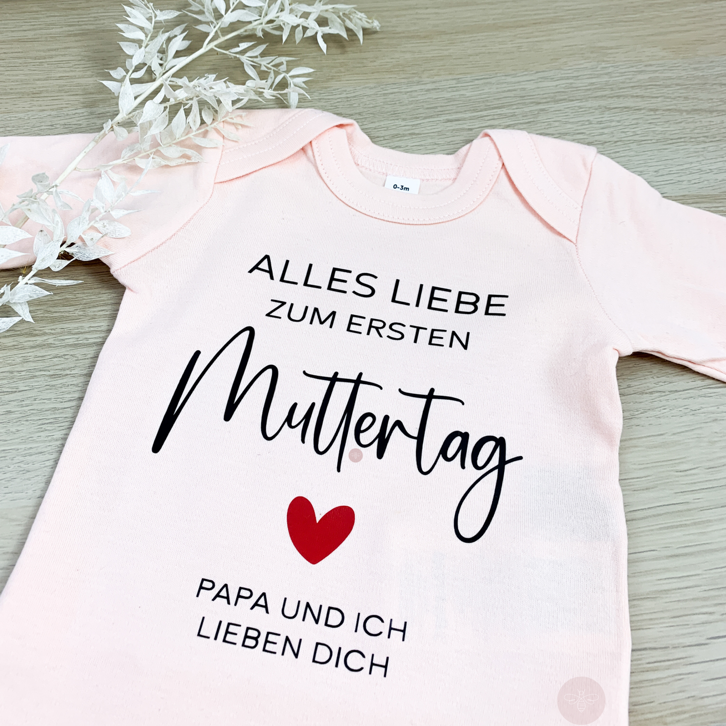 Babybody zum ersten Muttertag in Lachs mit liebevoller Aufschrift.