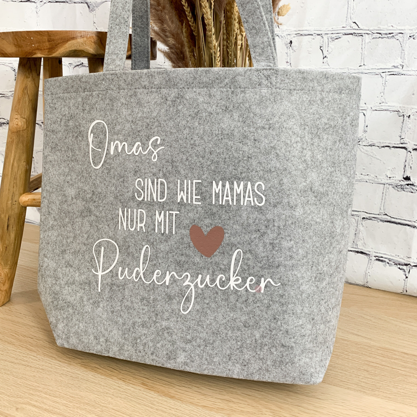 Hellgrauer Filzshopper mit weißer Aufschrift "Omas sind wie Mamas nur mit Puderzucker" und roséfarbenem Herz – ein liebevolles Geschenk für Omas.