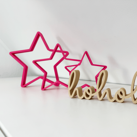 Festliche Kombination aus Magenta 3D Sternen und hohoho Deko-Schriftzug auf weißer Fläche