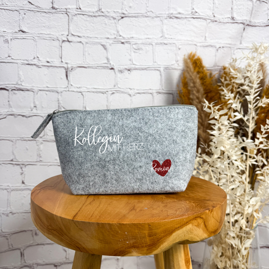 Hellgraue Filz-Kosmetiktasche mit „Kollegin mit Herz“ Schriftzug und rotem Glitzerherz – ein persönliches Geschenk zum Abschied einer Kollegin.