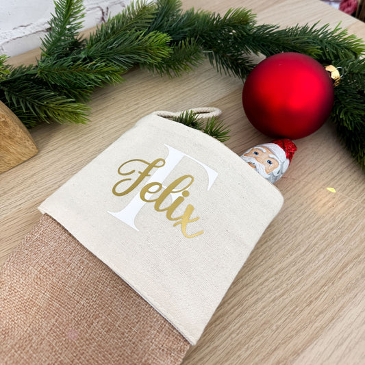 Der personalisierte Nikolausstrumpf mit der Initiale „F“ und dem Namen „Felix“, gefüllt mit einem Schokoladen-Weihnachtsmann. Ein liebevolles Nikolausgeschenk.