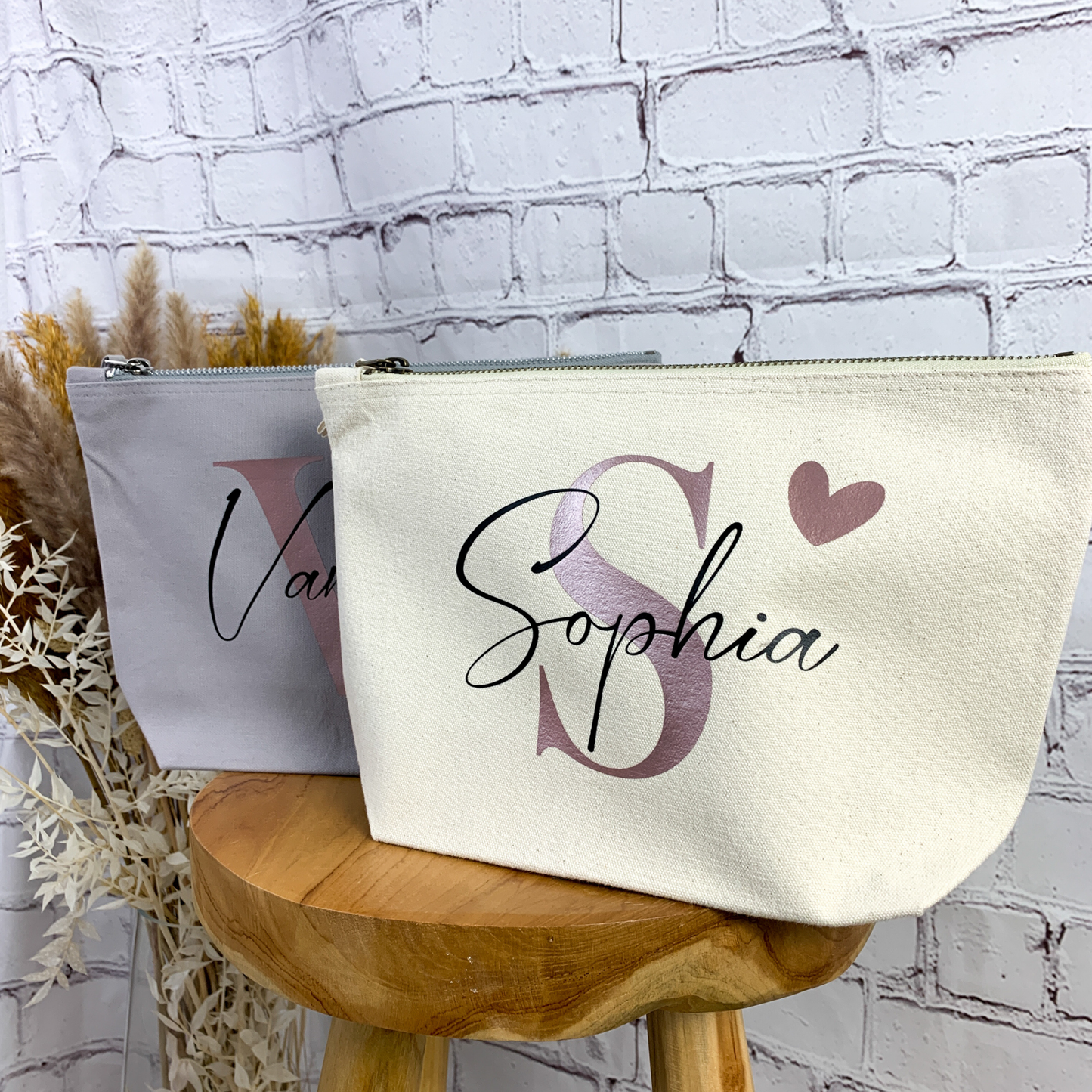 Set personalisierter Kosmetiktaschen in Natur und Grau mit den Namen "Sophia" und "Vanessa".