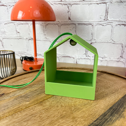 Einzelne 3D-gedruckte Vogelfutterstation in Hellgrün mit grünem Band und grüner Holzperle