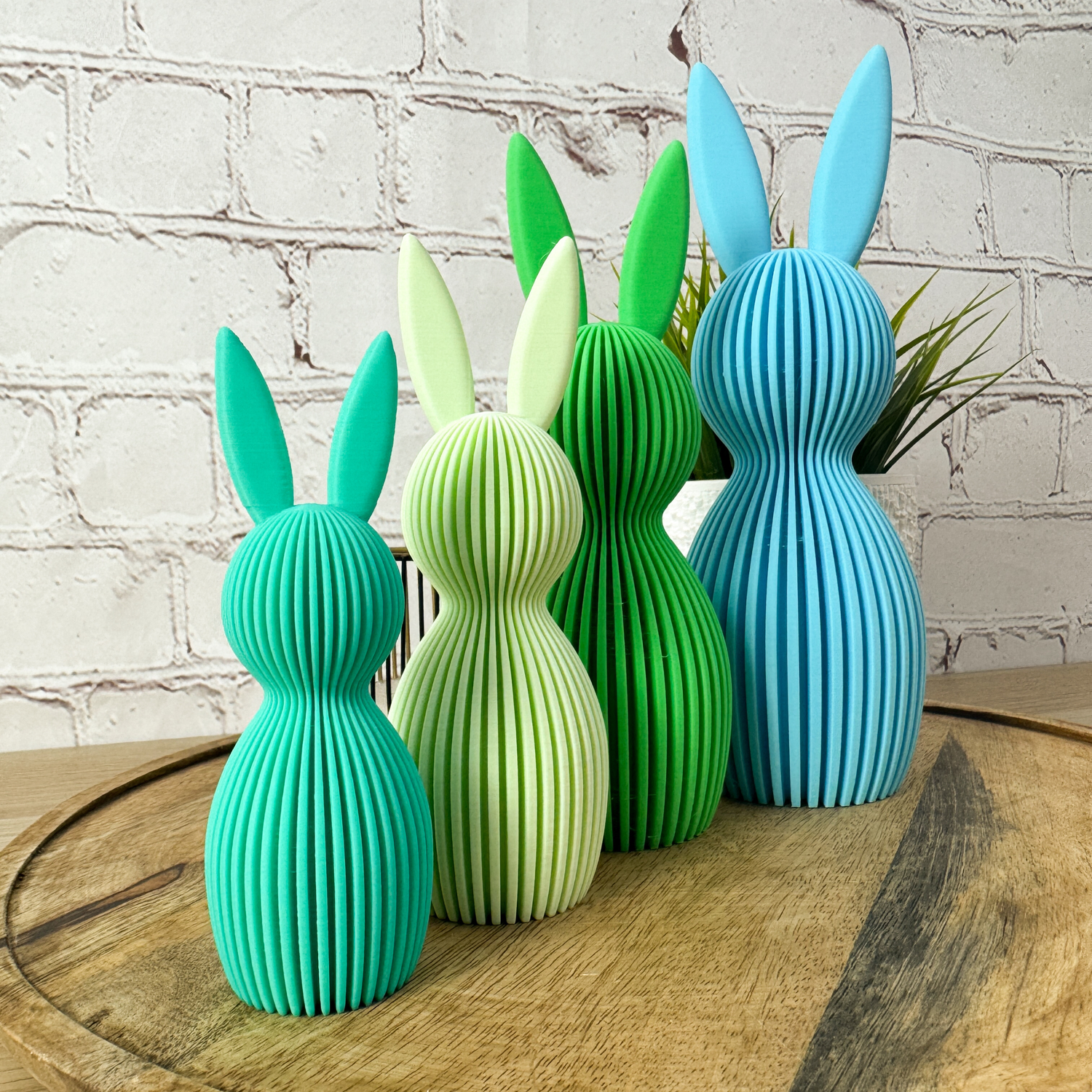 Vier geriffelte Osterhasen aus 3D Druck in verschiedenen Grüntönen und Blau, als dekoratives Set angeordnet