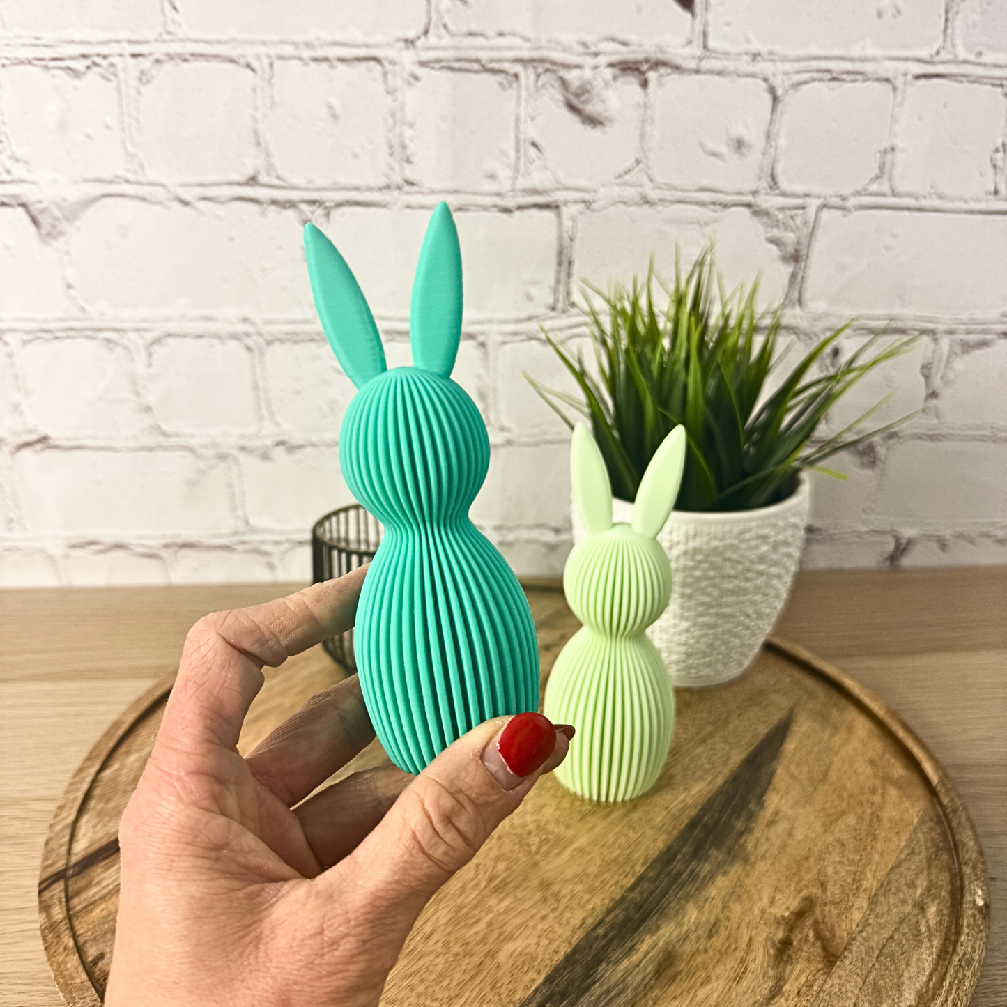 Geriffelter 3D Osterhase in Türkis, in der Hand gehalten mit weiterem Hasen im Hintergrund