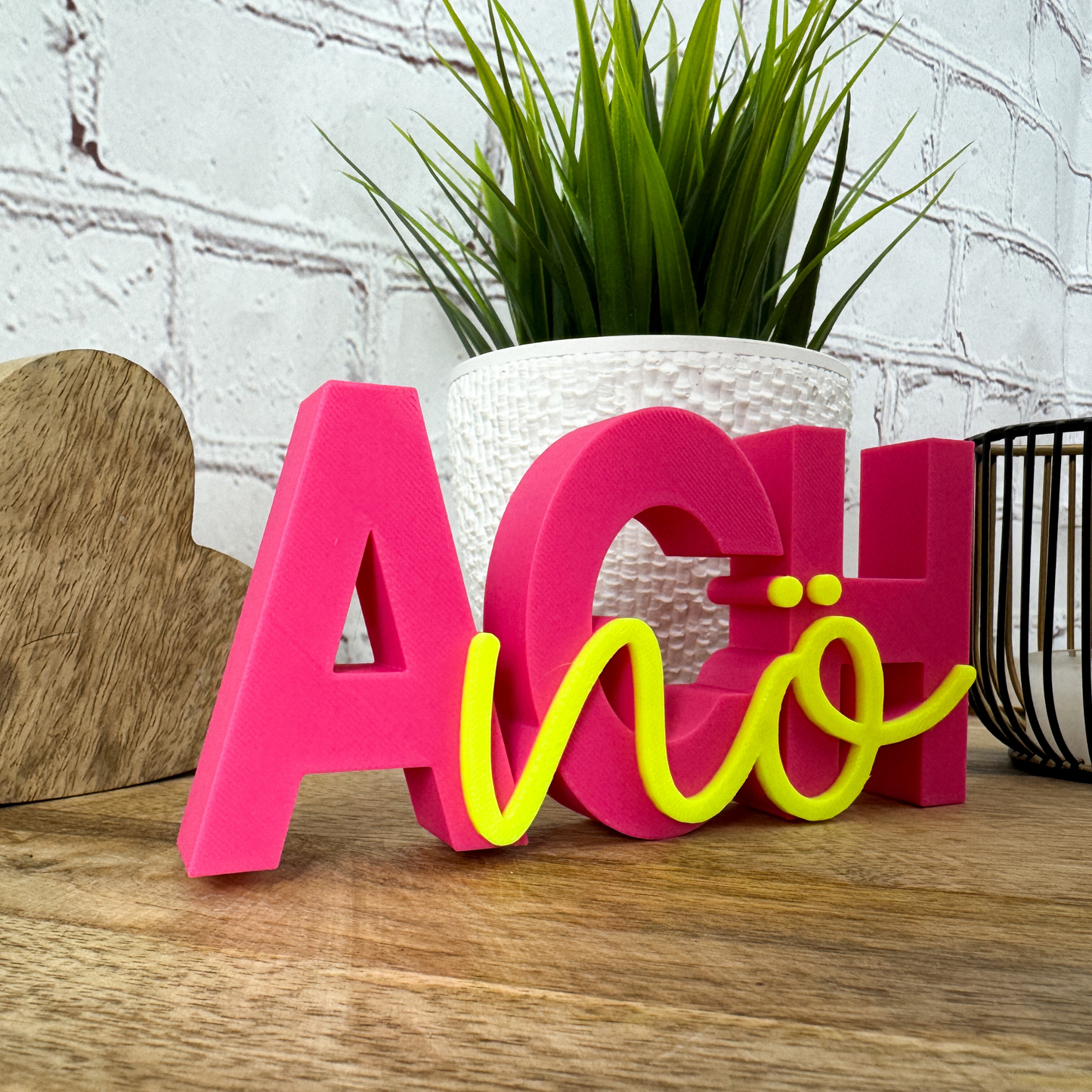 Dekoration „Ach nö“ aus PLA+ mit Pflanzen und Holzherz im Hintergrund