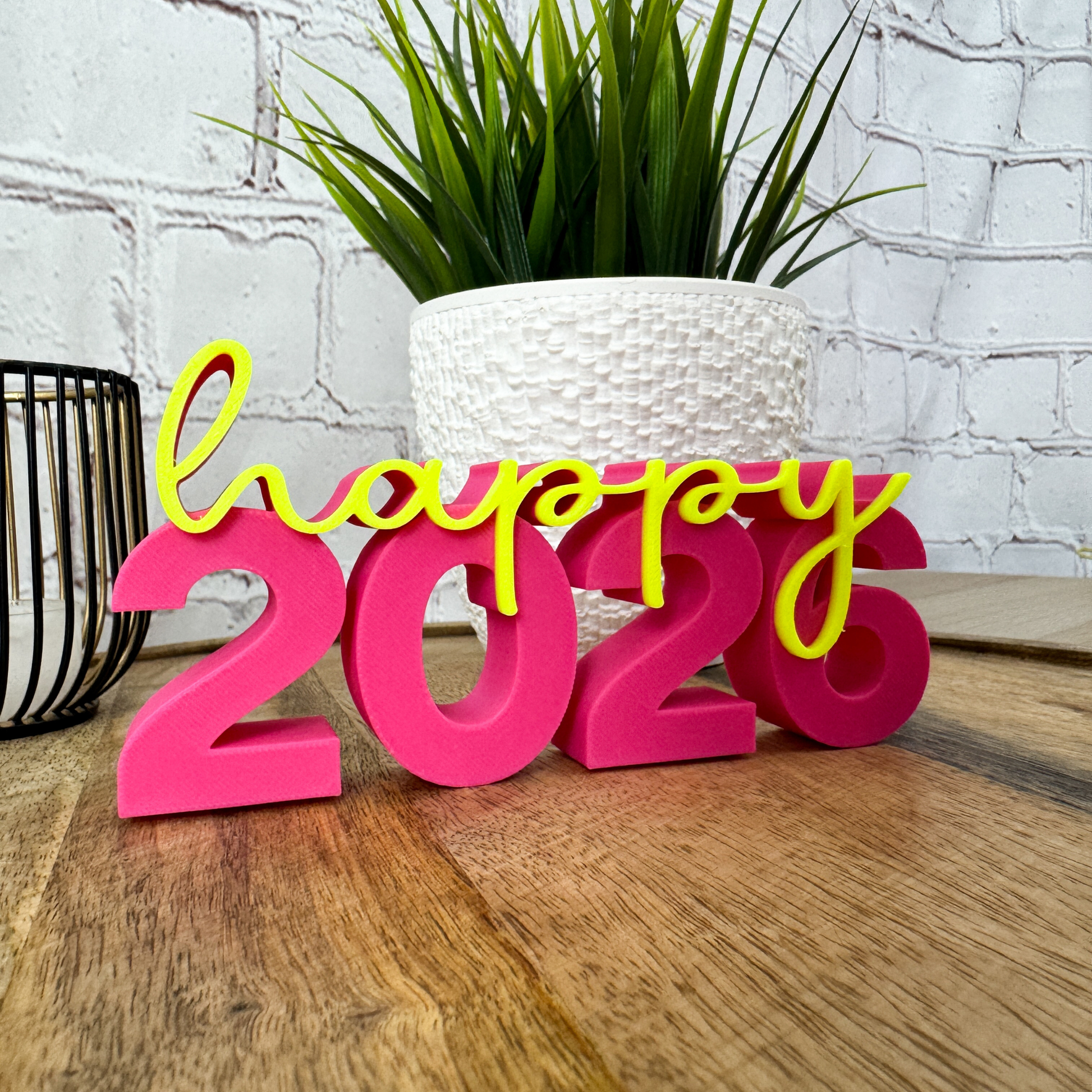 Nahaufnahme 3D Schriftzug „happy 2026“ aus PLA, Silvester-Deko in leuchtenden Farben auf Holz
