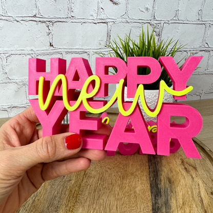 3D Schriftzug „happy new year“ in der Hand gehalten, farbenfrohe Silvester-Deko aus PLA