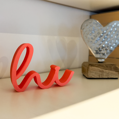 Rosa 3D-Schriftzug „hi“ aus PLA im Regal, neben Deko-Herz und Büchern – kleine liebevolle Wohn-Deko
