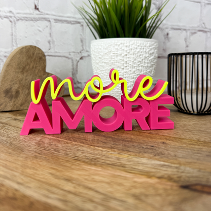 3D Schriftzug „more Amore“ als Valentinstag Deko in Magenta und Neon Gelbauf Holztisch dekoriert