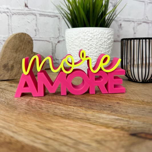 3D Schriftzug „more Amore“ als Valentinstag Deko in Magenta und Neon Gelbauf Holztisch dekoriert