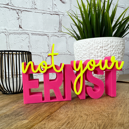 3D Schriftzug „not your ernst“ aus PLA in Pink mit gelber Schrift, stehende Deko auf Holzuntergrund