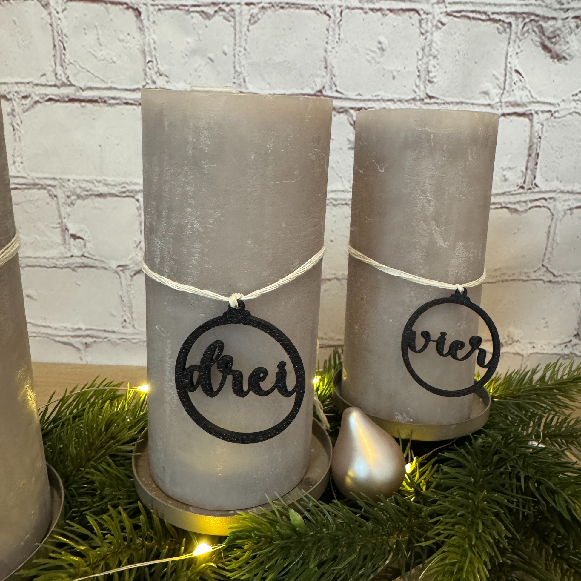 Detailaufnahme der Adventszahlen „drei“ und „vier“ – moderne schwarze Anhänger für Adventskerzen