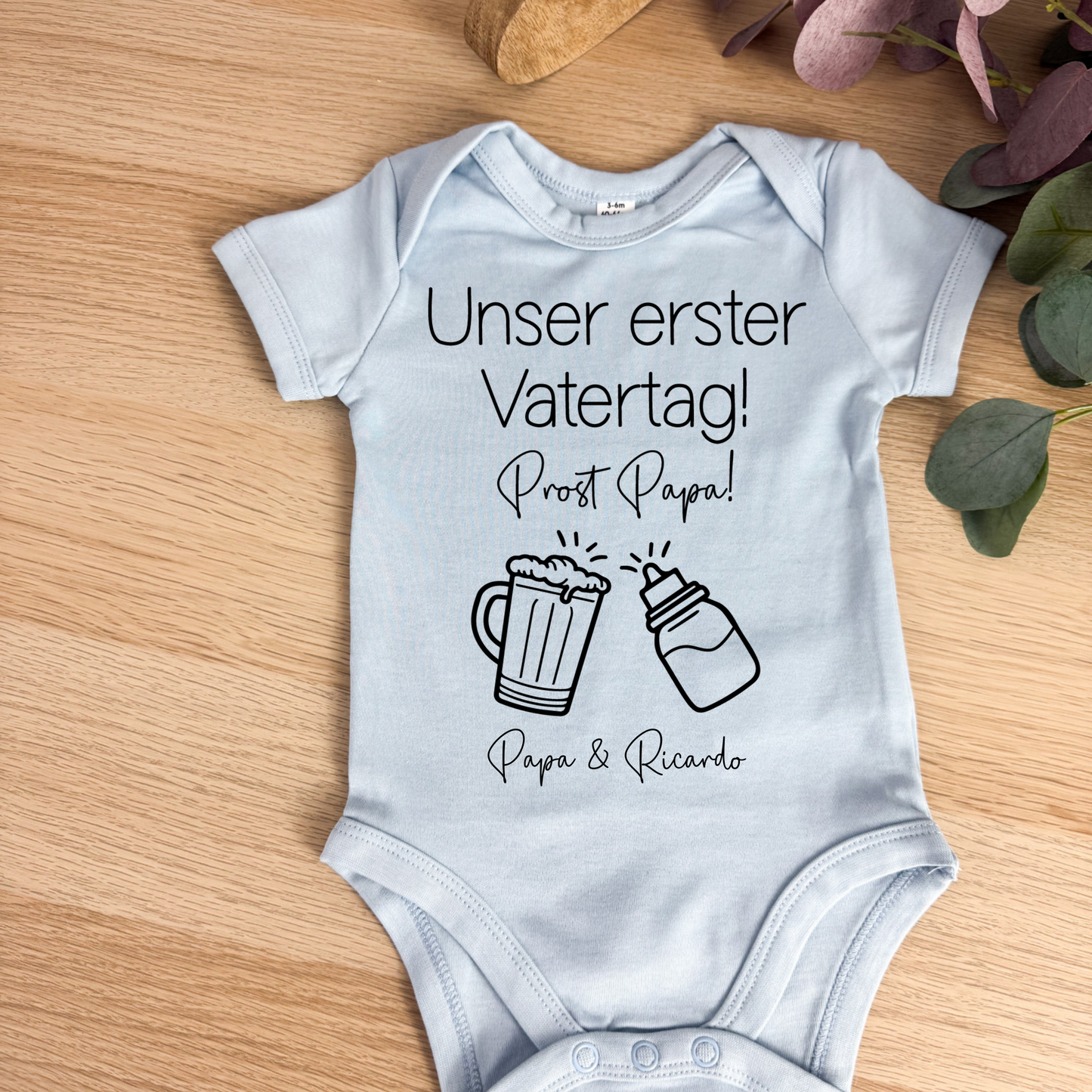 Hellblauer Babybody aus Bio-Baumwolle mit liebevollem Vatertagsmotiv – ein unvergessliches Geschenk für den ersten Vatertag.