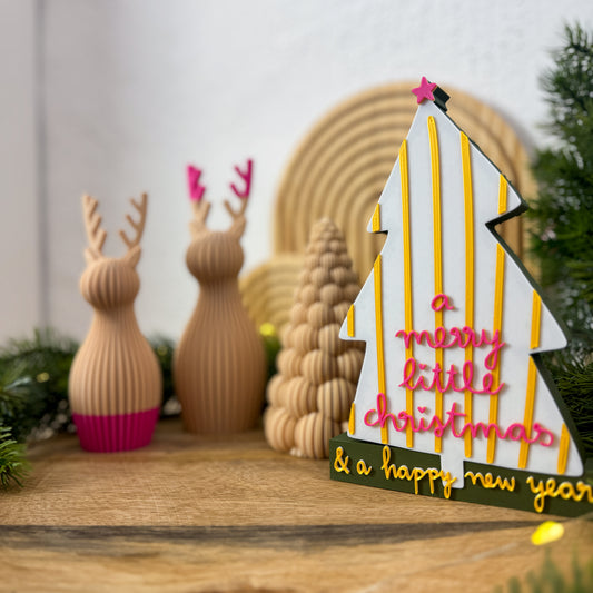 Nahaufnahme des Schriftzugs „& a happy new year“ in Gold auf dunkelgrünem Sockel