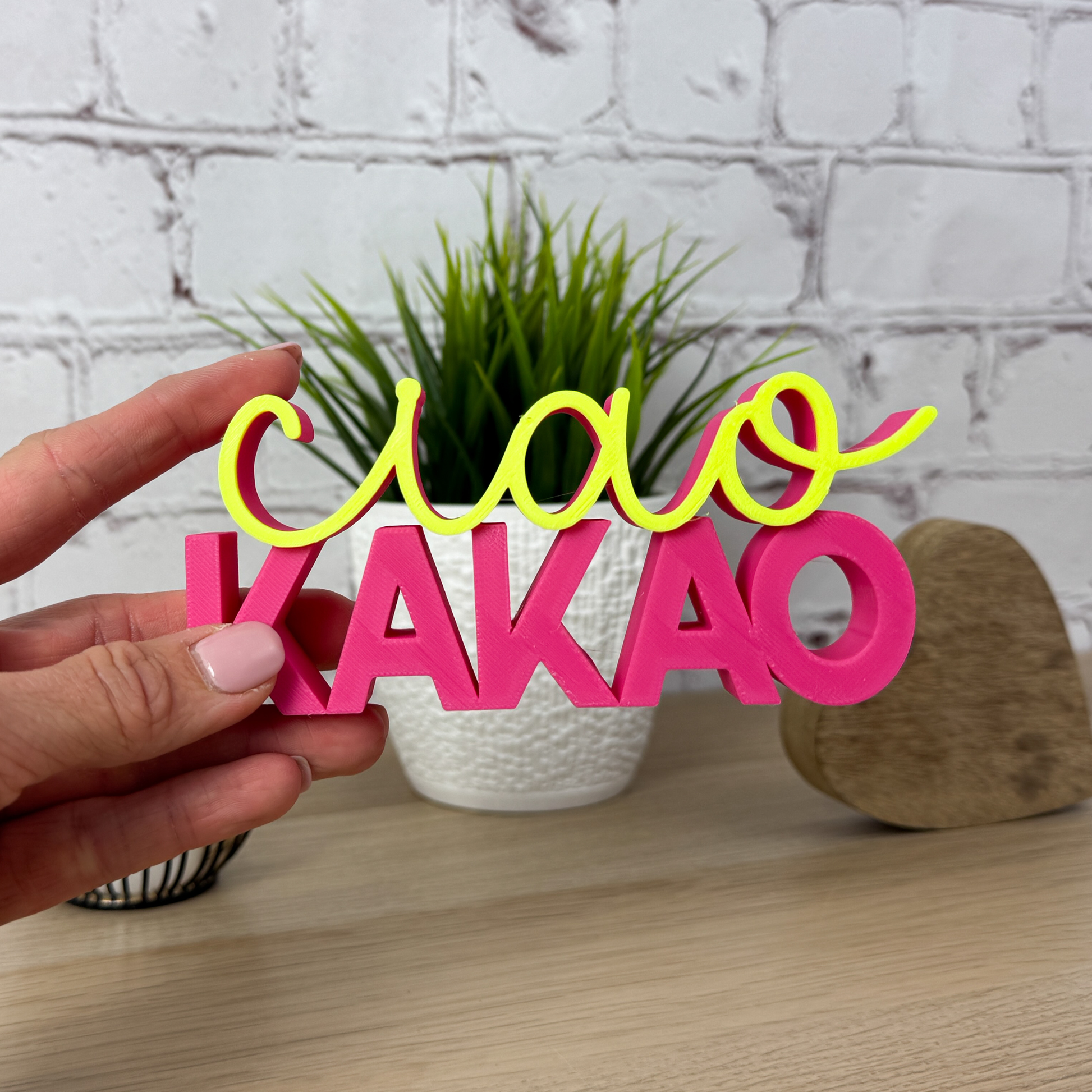 Hand hält bunten Schriftzug 'ciao kakao' aus PLA+, farbenfroh und perfekt als Geschenkidee
