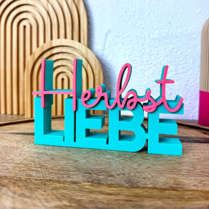 Herbst Liebe Schriftzug steht frontal als 3D Tischdeko in Türkis und Pink.