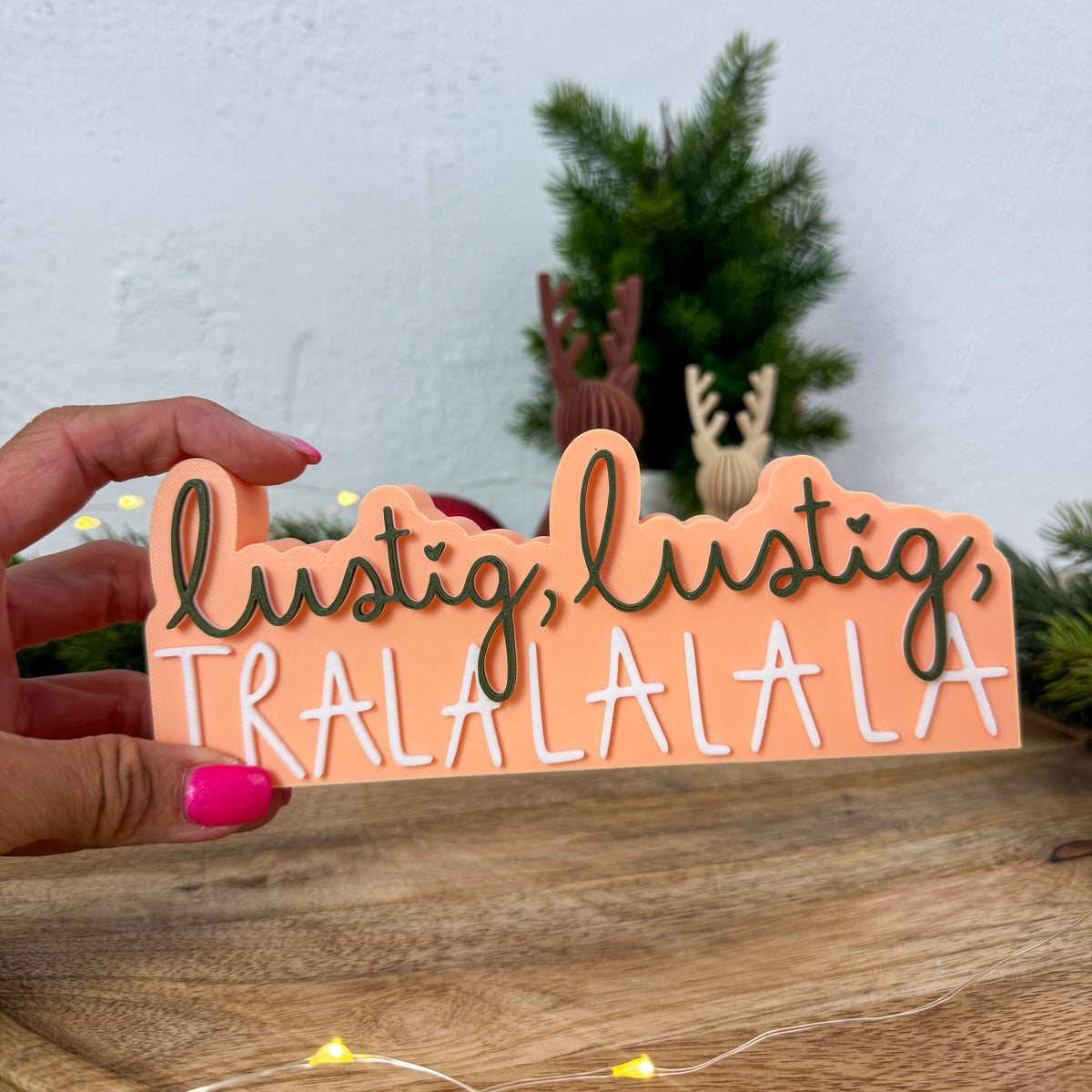Nikolaus-Spruch „lustig, lustig, tralalala" in einer Hand gehalten als Größenvergleich