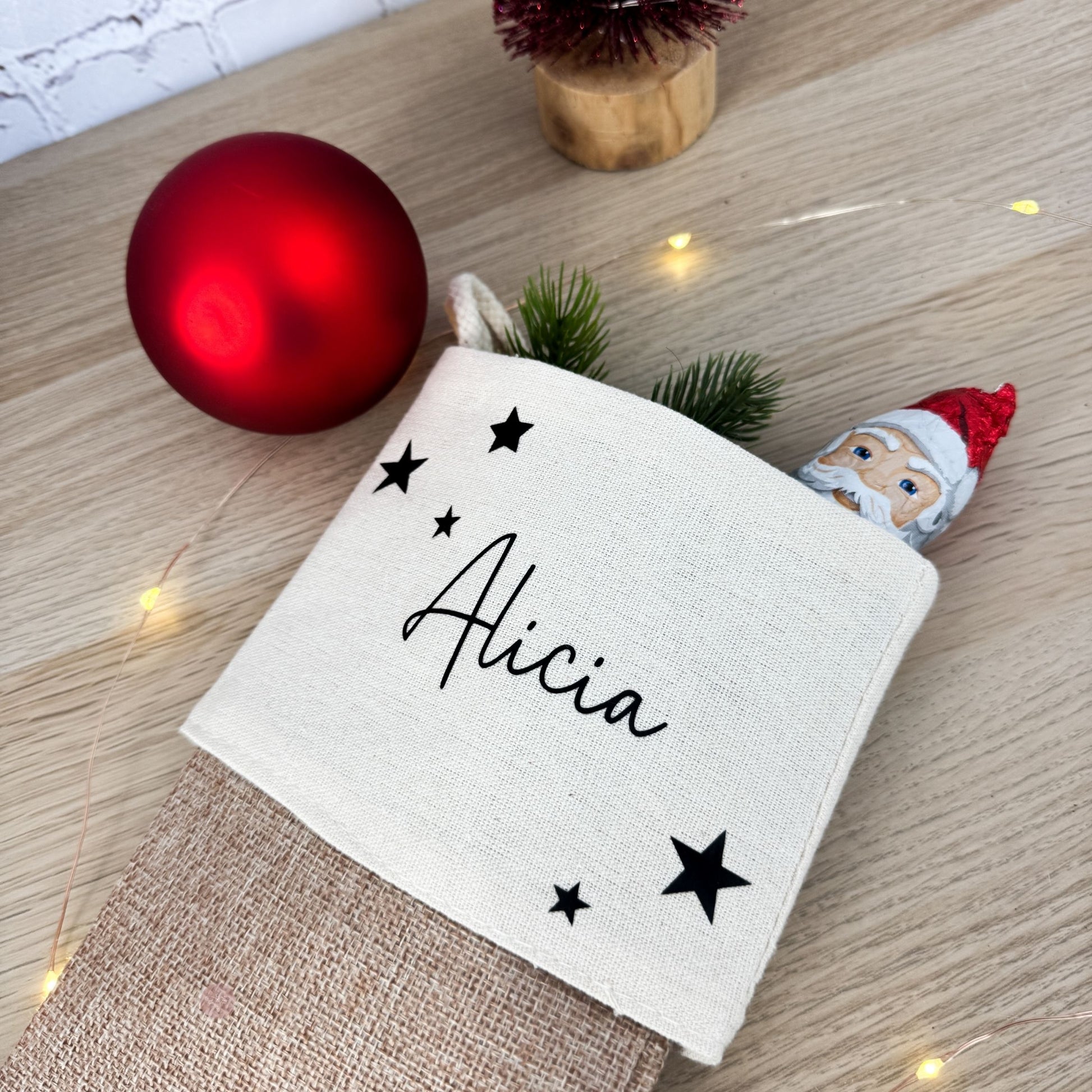Nahaufnahme einer gefüllten Nikolaussocke mit dem Namen "Alicia" und schwarzen Sternen. Ein liebevolles Geschenk zum Nikolaus.