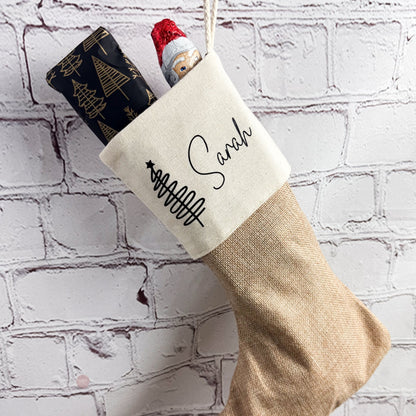 Nikolaussocke mit Name Sarah an einer Backsteinwand aufgehängt, gefüllt mit Nikolaus und Geschenk – festliche Dekoidee.