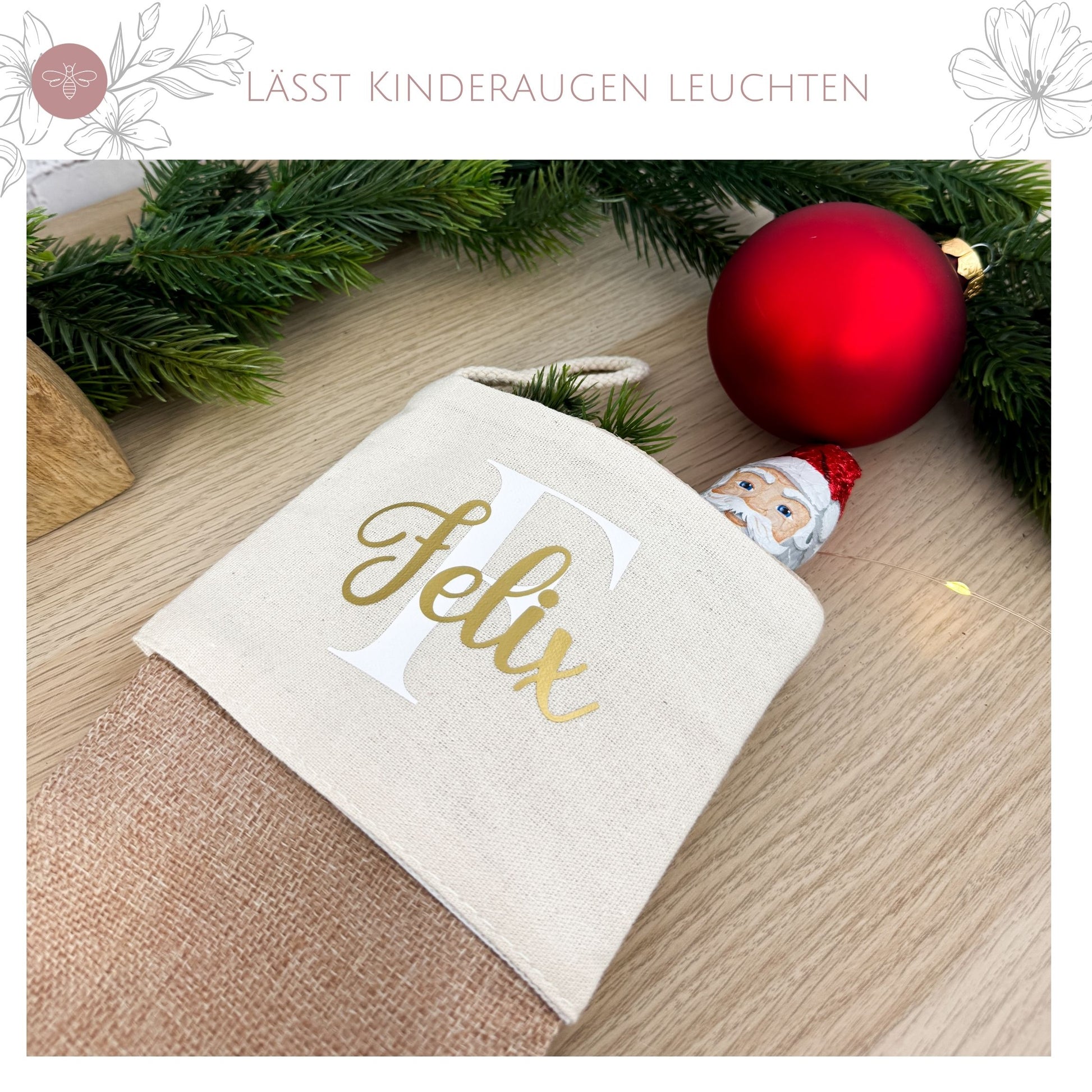 Der personalisierte Nikolausstrumpf „Felix“ gefüllt mit einem Schokoladen-Weihnachtsmann, umringt von Tannenbaumschmuck.
