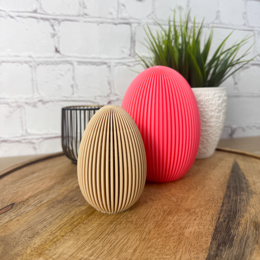 Geriffeltes 3D Osterei aus PLA in Natur und Pink als moderne Oserdeko auf Holzuntergrund