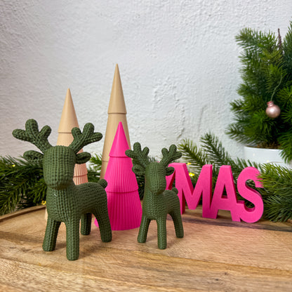 Rentier Figur in Strickoptik als Weihnachtsdeko neben „XMAS"-Schriftzug in Pink