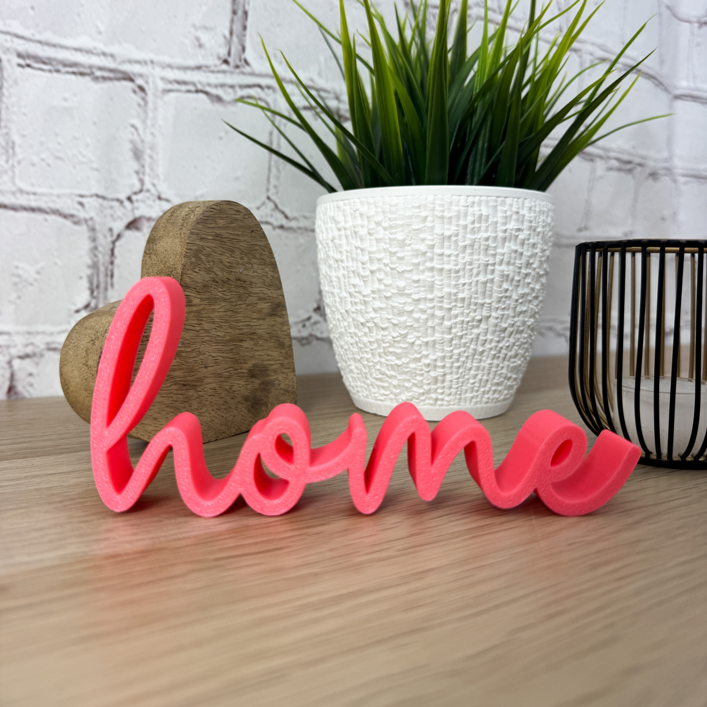 3D-Dekoschriftzug 'home' in Pink aus PLA+ mit Herz und Pflanze im Hintergrund – perfekte Einweihungsgeschenkidee.