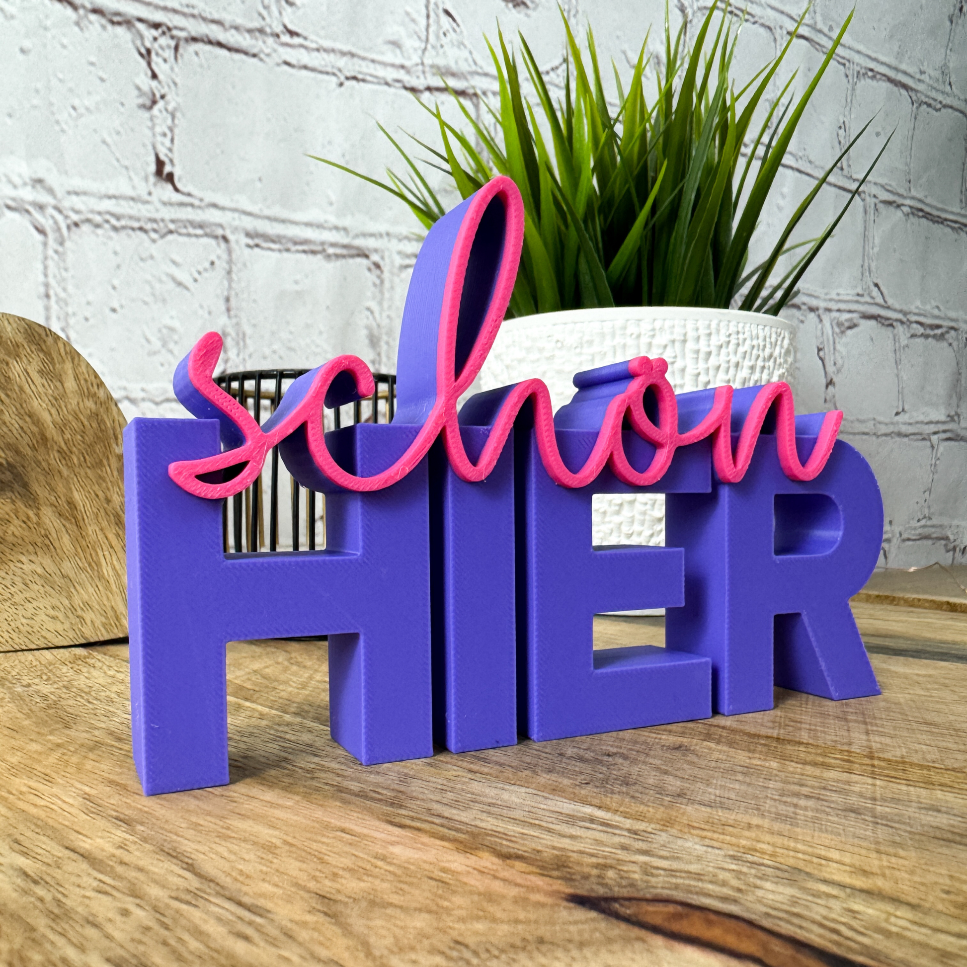 Deko-Schriftzug „schön hier“ in Lila mit pinker Schrift – moderne Farbkombination für Wohnung oder Büro