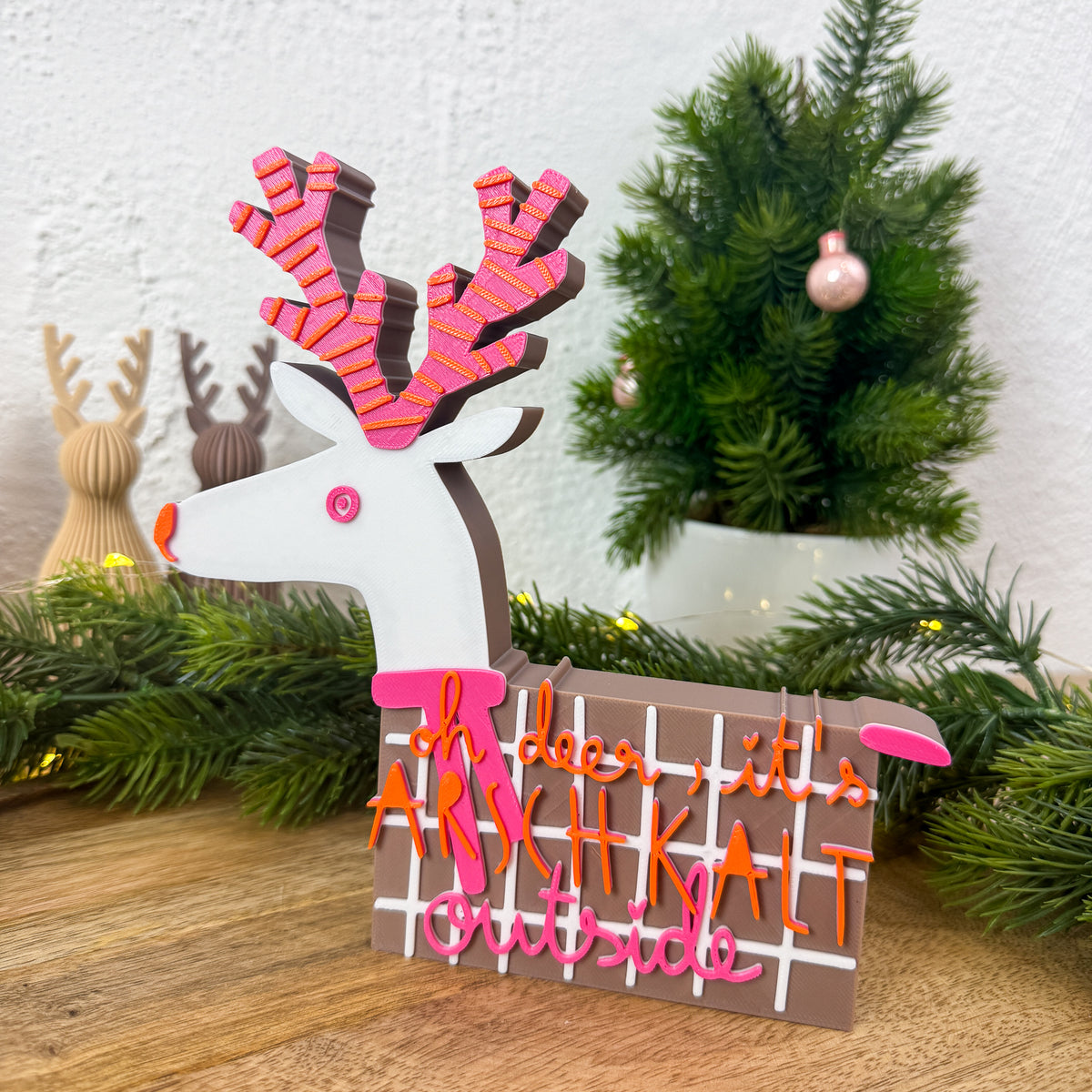 Winter Schriftzug als Weihnachtsdeko neben Deko-Tannenbaum und weiteren Rentierfiguren
