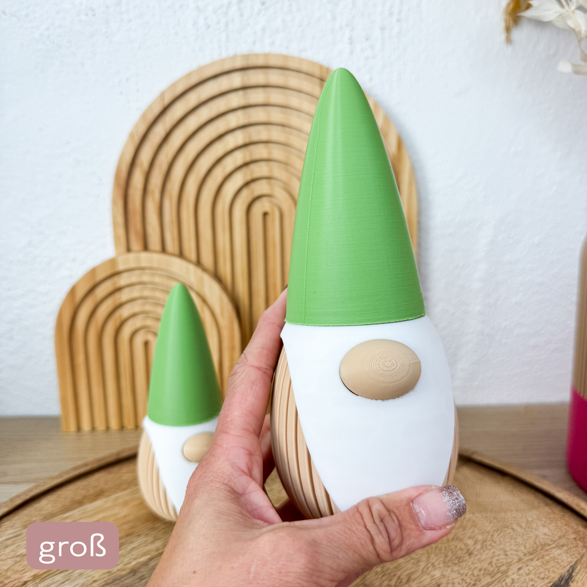 Wichtel Deko 3D Zwerg in der großen Größe 18,5 cm in einer Hand gehalten, kleine Größe im Hintergrund